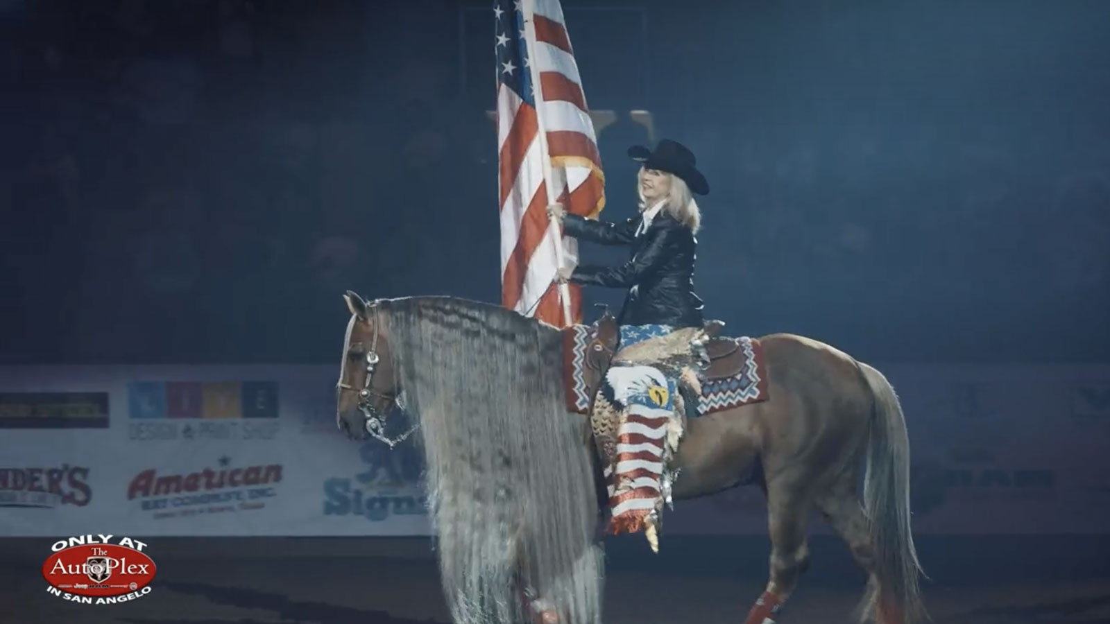 San Angelo Mayor Brenda Gunter presents the Stars and Stripes during the opening ceremony of the 10th Annual Cinch Chute Out