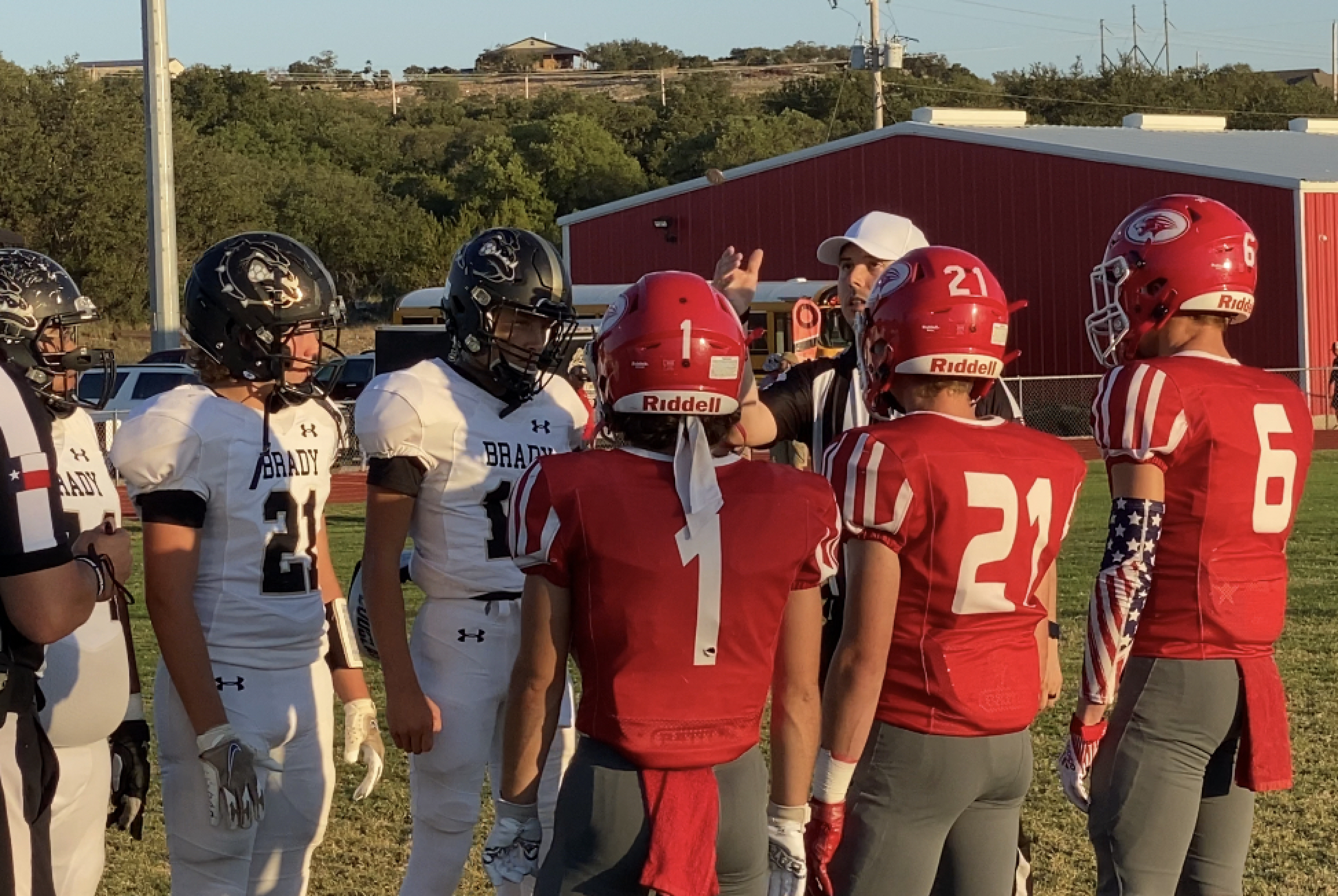 Captains for the Brady Bulldogs and Christoval Cougars meet at midfield for the coin toss.