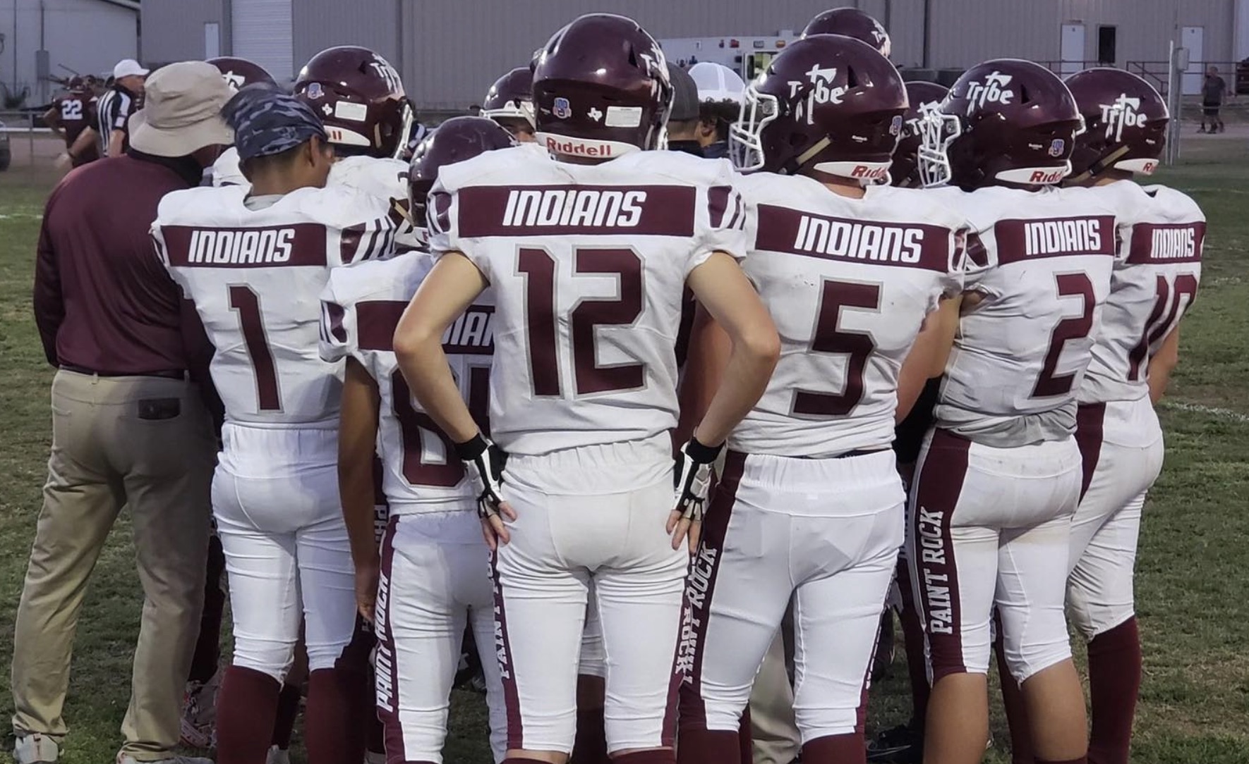The Paint Rock Indians football team meets with their coach during a game in 2020.