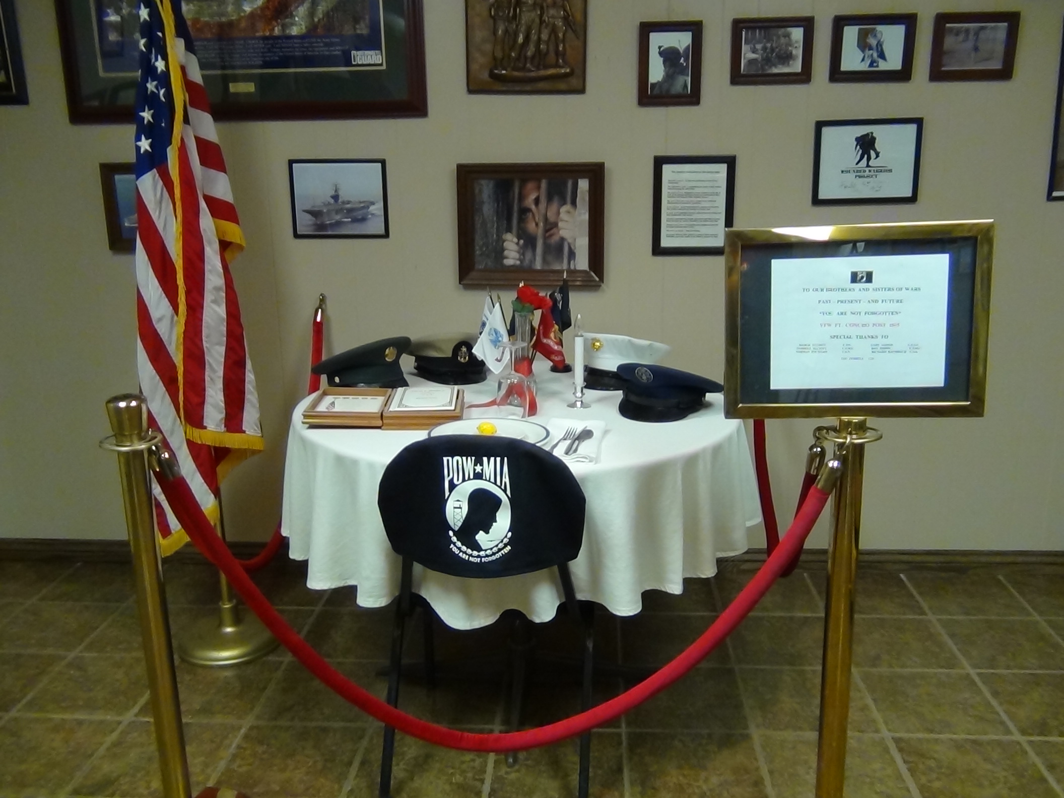 Various awards, medals and photographs populate the wall space, and the POW MIA chair is focused upon (LIVE! photo by Cheyenne Benson)