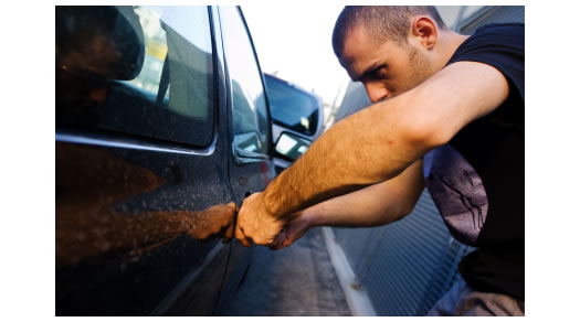 A thief prepares to break into a car (photo courtesy of naylornetwork.com)