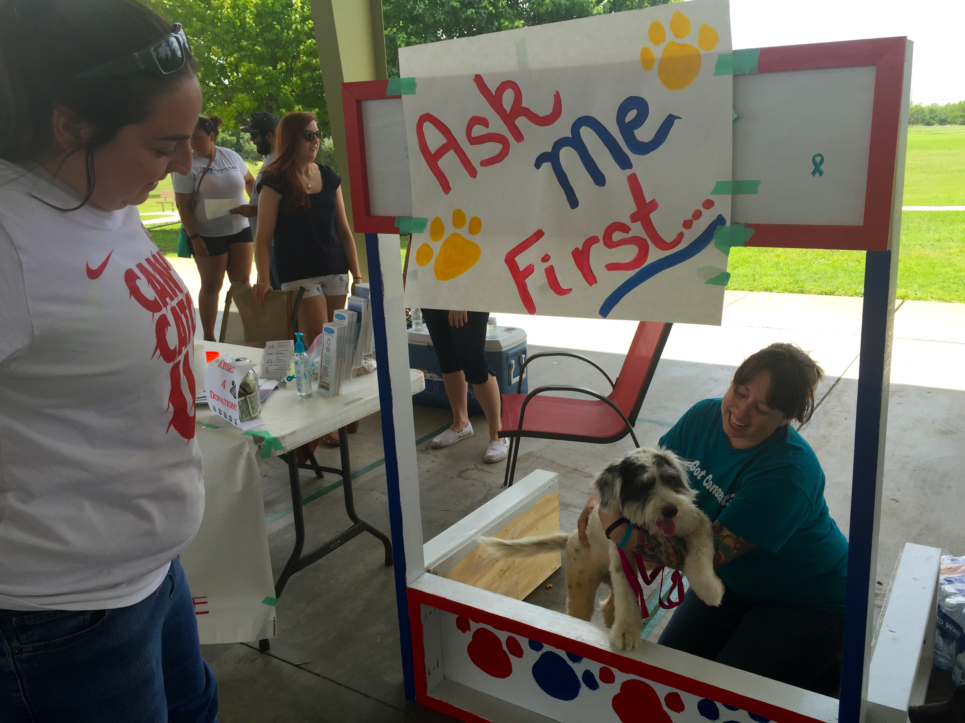 Volunteers accept donations at puppy kissing booth. (LIVE! Photo/Jessica Wilder)