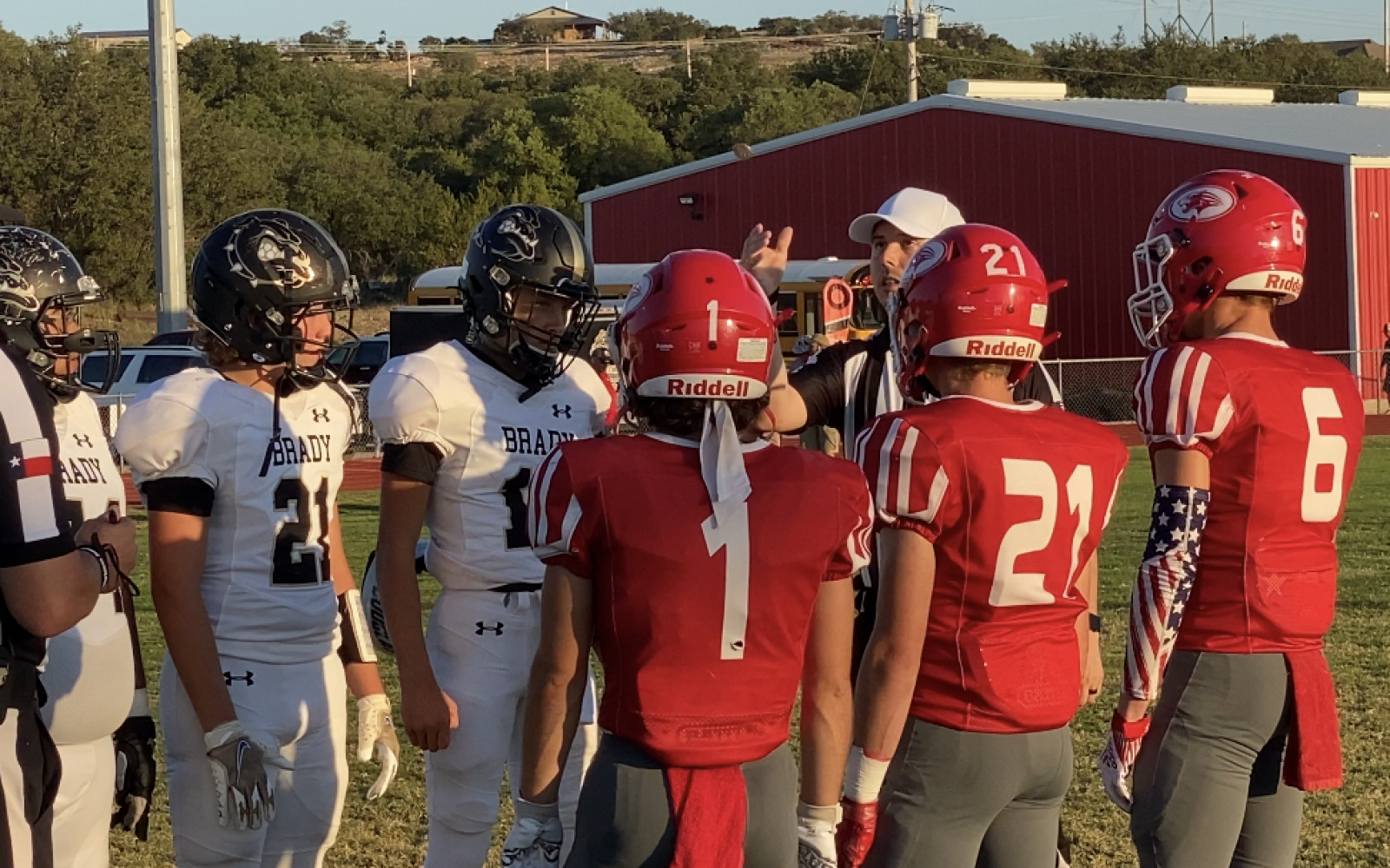 Captains for the Brady Bulldogs and Christoval Cougars meet at midfield for the coin toss.