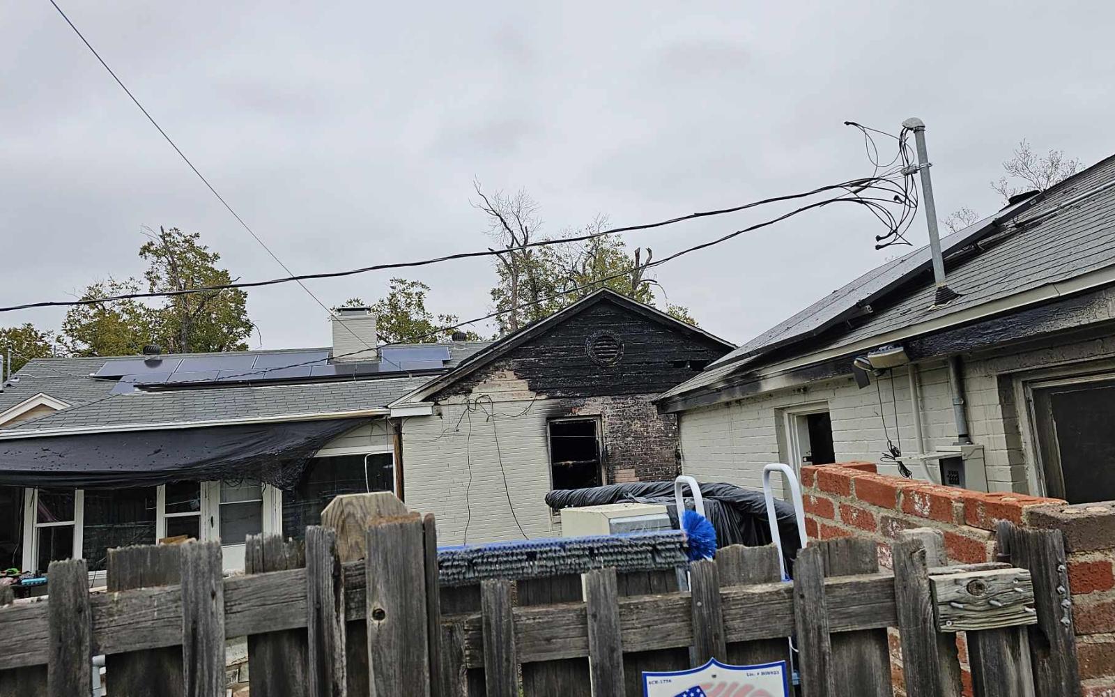 The view from the back alleyway of the garage (right) and damage to the house from the Nov. 24, 2023 fire.