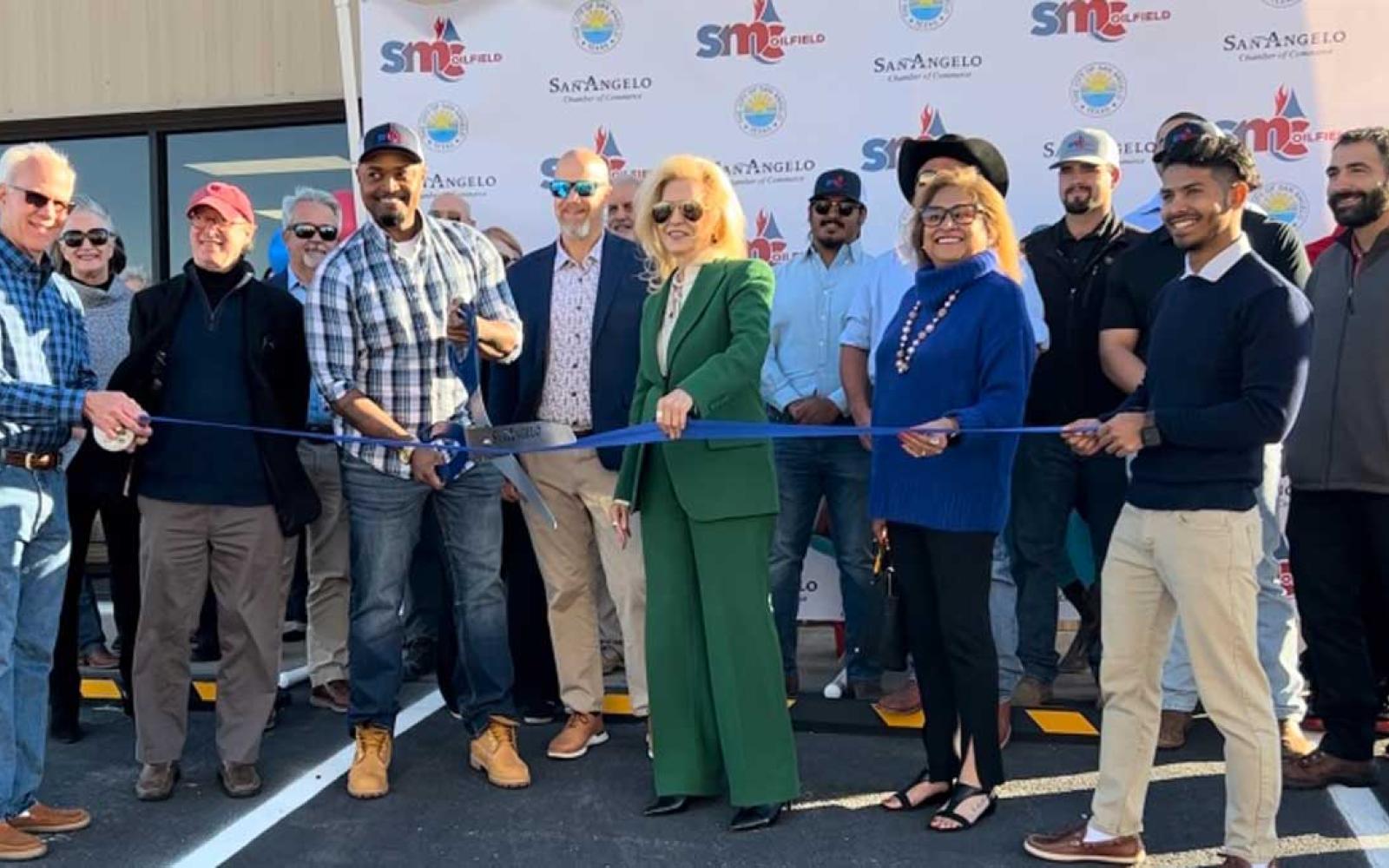 Mayor Brenda Gunter (center in green) celebrates the ribbon cutting of the new SMC expanded facility. 