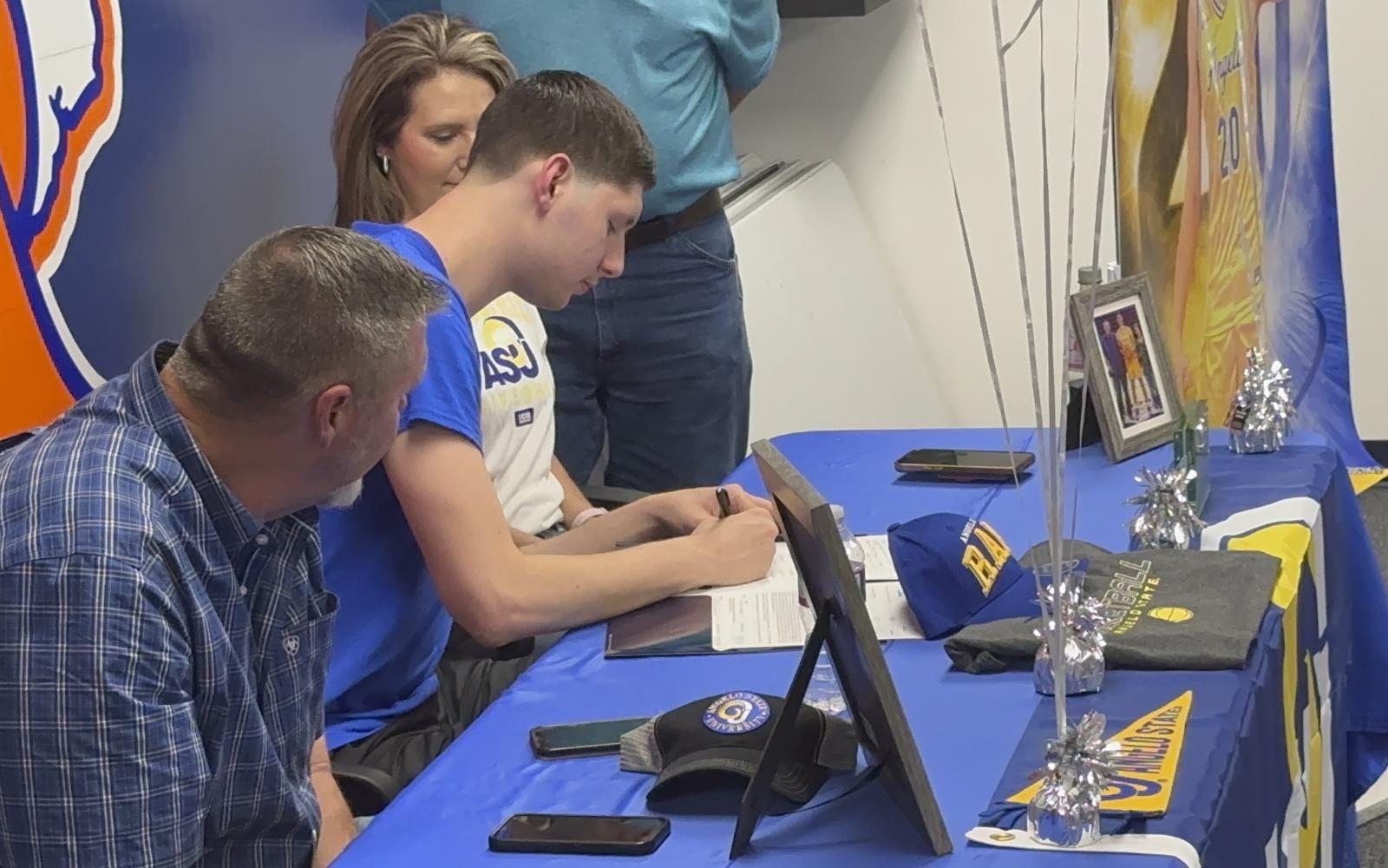 Kollin Allbright signing his papers with Angelo State