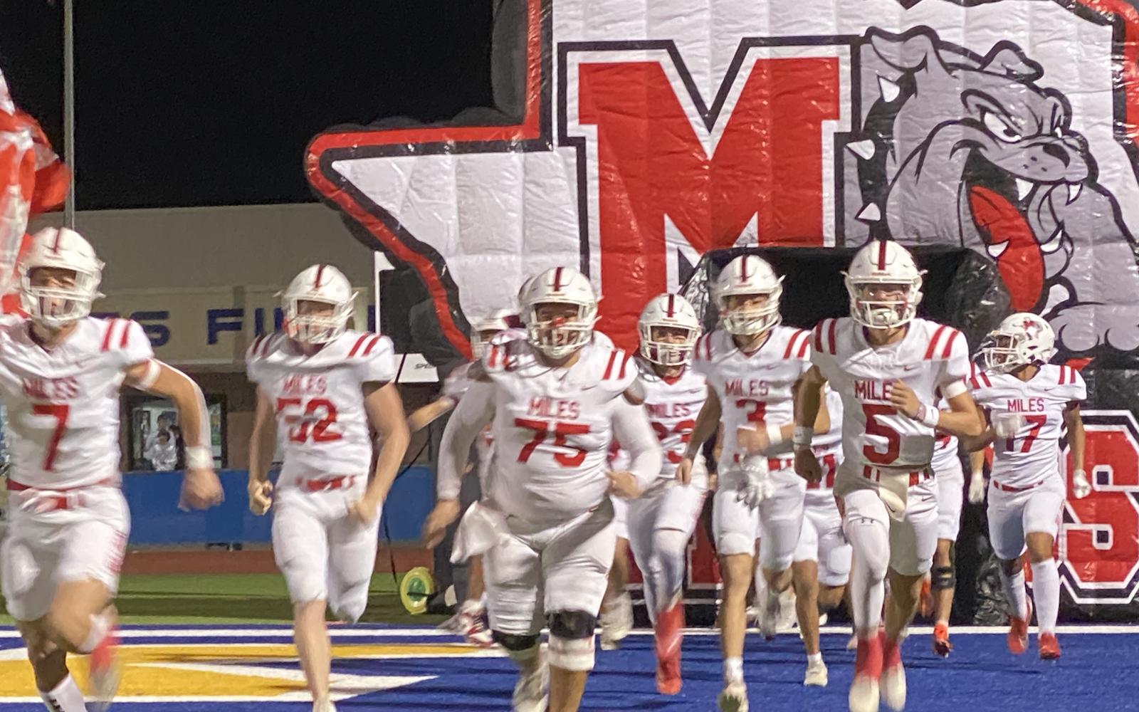 The Miles Bulldogs charge onto the field before their first-round playoff game against Lindsay on Thursday, Nov. 14, 2024.