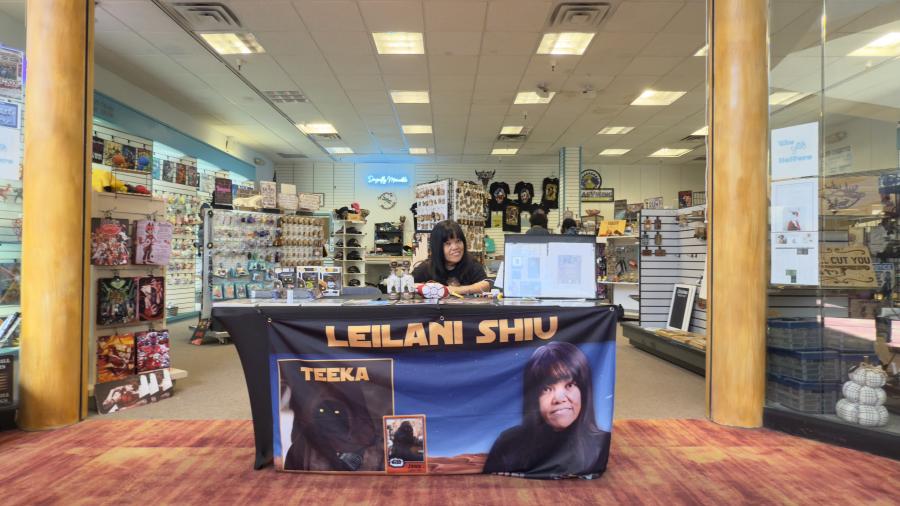 Leilani Shiu, dressed as Teeka the Jawa, showcases her Star Wars action figure while signing for fans and collecting toys for the Ronald McDonald House at the Sunset Mall in San Angelo.