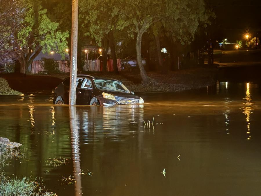 A stranded SUV sits partially submerged near Spaulding Street in San Angelo, where swift floodwaters required a water rescue for the four occupants inside. Emergency responders continue to caution against driving through flooded areas.