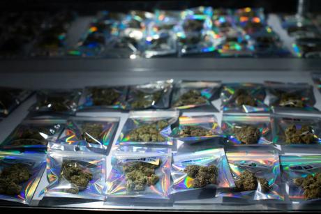Individual packages of THC-A flower are seen in a display case at a smoke shop in Austin on May 13, 2026.