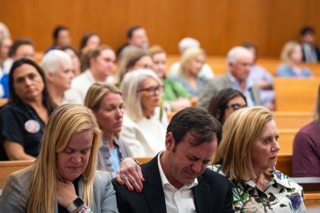Edward Eastland breaks down in tears as he’s comforted by Tweedy Eastland, right, and Mary Liz Eastland, left, during a hearing on a lawsuit against Camp Mystic in an Austin courtroom on April 14, 2026.