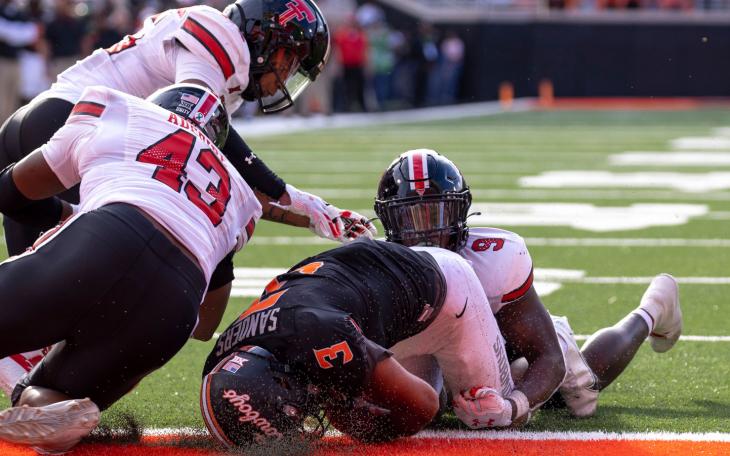Texas Tech's Joseph Adedire (43), Dadrion Taylor-Demerson (25), and Marquis Waters (9) attempt to tackle Oklahoma State's Spencer Sanders (3) during the second half of an NCAA college football game in Stillwater, Okla., Saturday, Oct. 8, 2022. (AP Photo/Mitch Alcala)