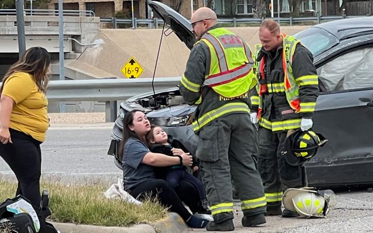 The mother is comforting her child after both escaped death in a 3-time rollover crash next to the Houston Harte on Dec. 1, 2022.