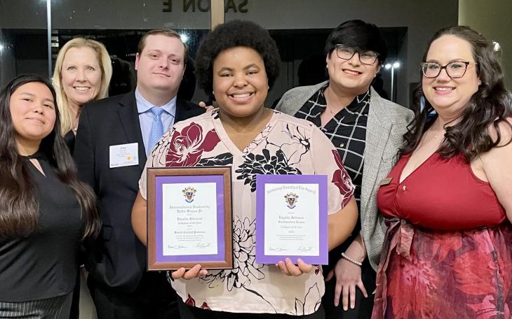 Daysha Johnson (center) with Delta Sigma Pi officials and her awards: