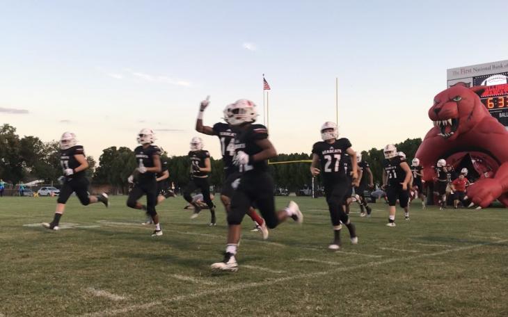 The Ballinger football runs onto the field before a game at Bearcat Stadium.