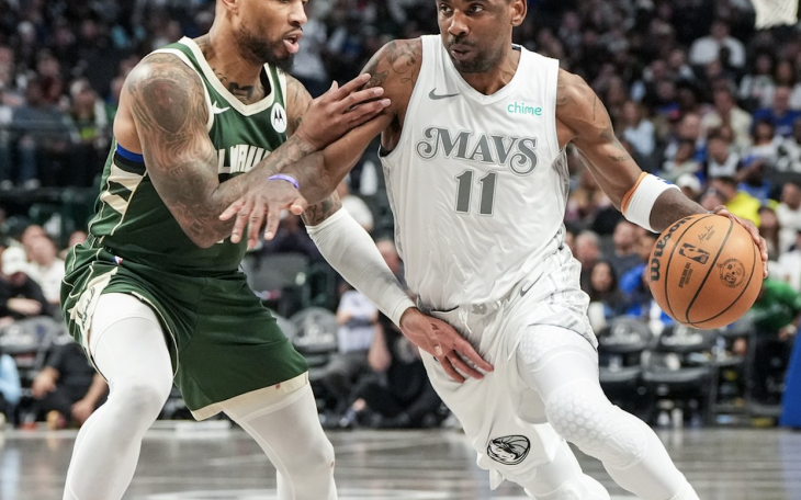 Kyrie Irving of the Dallas Mavericks drives past Damian Lillard of the Milwaukee Bucks