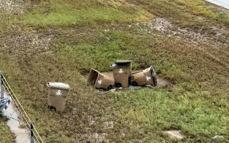 Many Toter trash containers washed into the Houston Harte Expy, likely from the East Ditch.