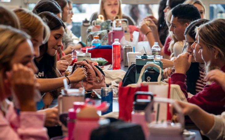 Students eat lunch without their smartphones at Lago Vista High School on Sept. 9, 2025. The school requires students to stow devices, primarily cell phones, in magnetically locked pouches that also block cell phone service. The pouches can be unlocked in an emergency and when the students exit the building, using a wall-mounted key near the building entrance.