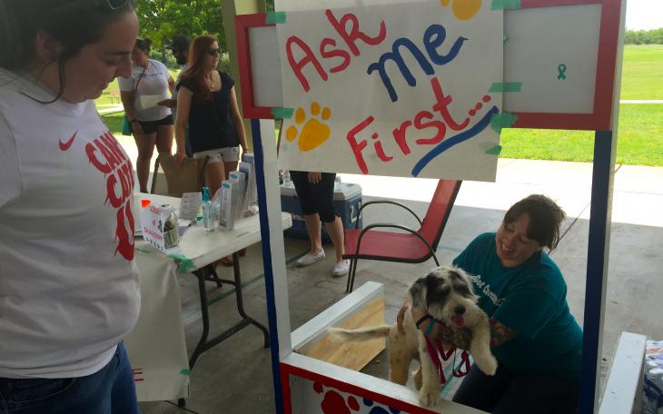 Volunteers accept donations at puppy kissing booth. (LIVE! Photo/Jessica Wilder)