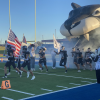 Water Valley's Branson Lacy (6) helps lead the Wildcats onto the field while carrying a flag.